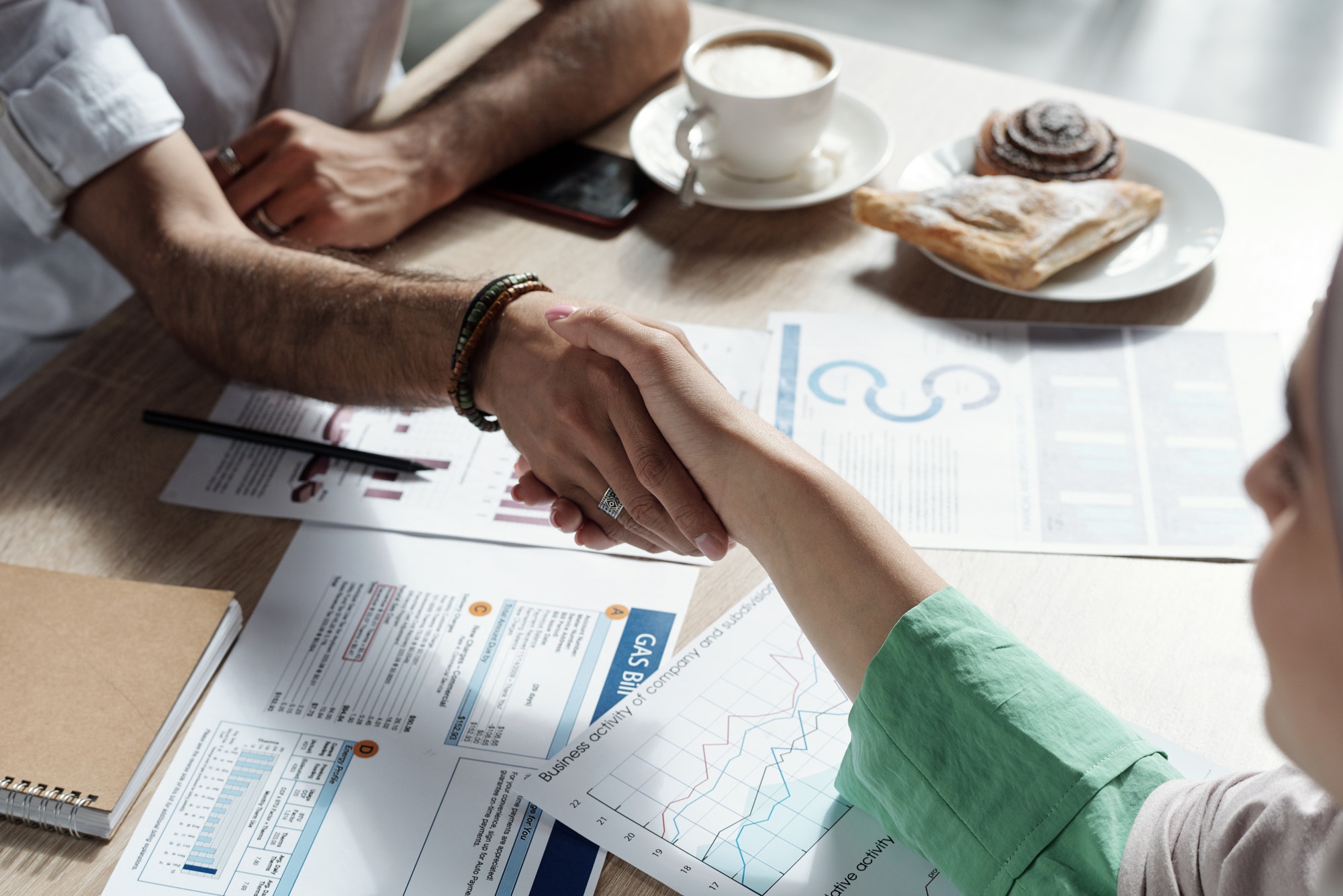 Young Arabic businesswoman shaking hand of male business partner